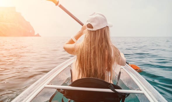 Woman in kayak back view. Happy young woman with long hair floating in transparent kayak on the crystal clear sea. Summer holiday vacation and cheerful female people having fun on the boat.