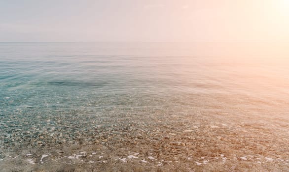 A calm body of water with a few rocks scattered throughout. The water appears to be clear and still, with no visible waves or ripples. The rocks are of various sizes