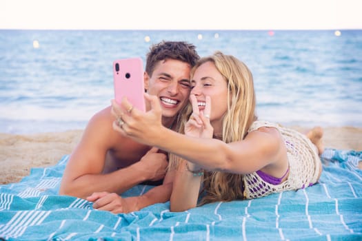 Smiling young woman and man enjoying vacation. Beautiful and cheerfulcoupleof generation z pose for a photo with a mobile phone.
