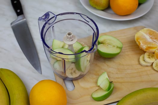 Fruits in blender before being crushed to create sports drink. Making fruit cocktail at home for healthy lifestyle