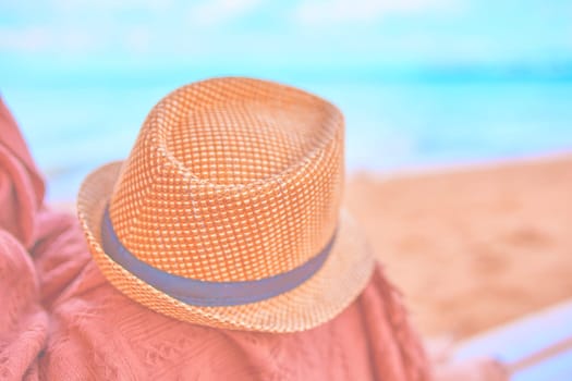 Straw hat on a hot day off on womans leg with plaid