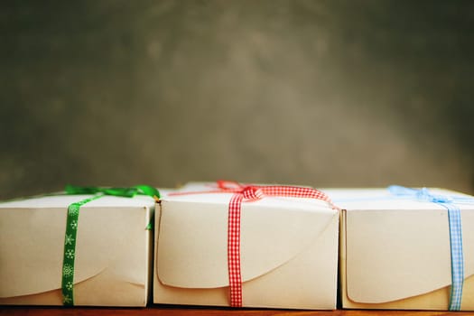 Stack of gift wrapped Christmas presents. The pile of boxes is stacked neatly on the table. Side view.