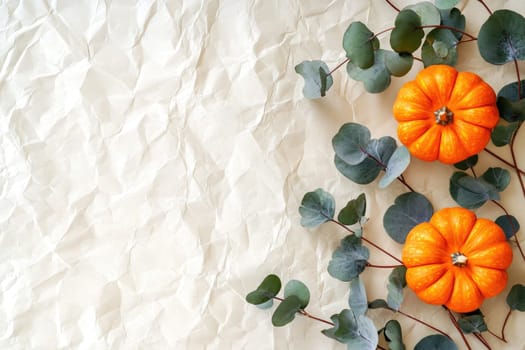 A beautiful arrangement showcases various pumpkins, cotton bolls, pinecones, and eucalyptus leaves framed on a soft background, reflecting the essence of autumn.