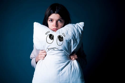 Funny girl with disgruntled offended face hugs a pillow. Young woman did not sleep well, she has trouble sleeping, woken up. Health problems with insomnia, need an orthopedic pillow, self-care, rest.