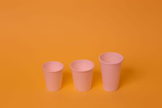 Take away a cup of coffee on orange paper background.