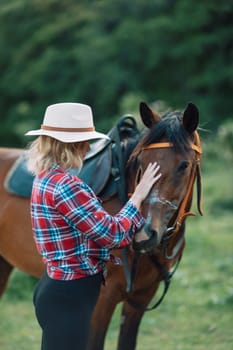 Happy blonde with horse in forest. Woman and a horse walking through the field during the day. Dressed in a plaid shirt and black leggings