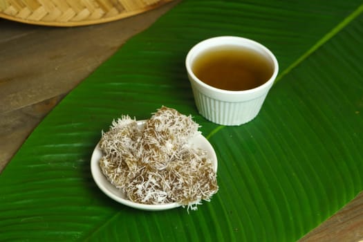 Kue Ongol-ongol is a traditional Indonesian snack made from tapioca flour and coconut milk, steamed in a banana leaf and served with brown sugar syrup. It has a chewy texture and a sweet, nutty flavor.