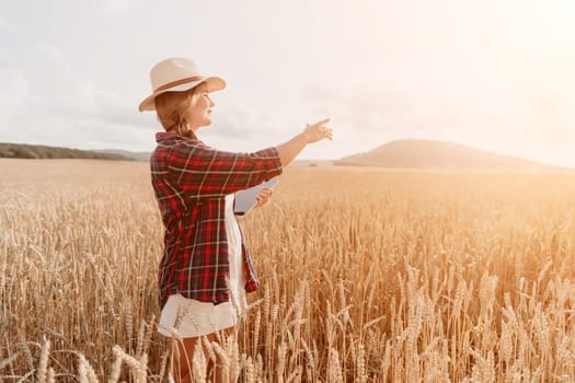 Woman farmer walks through a wheat field at sunset, touching green ears of wheat with his hands. Hand farmer is touching ears of wheat on field in sun, inspecting her harvest. Agricultural business.