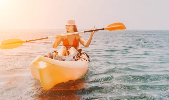 Happy smiling woman in kayak on ocean, paddling with wooden oar. Calm sea water and horizon in background