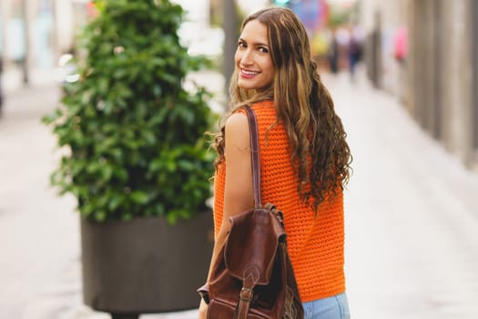 Casual latin woman smile in the city while walking