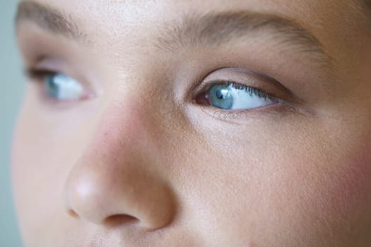 Hyper close-up of the blue eyes of a caucasian elegant woman looking aside