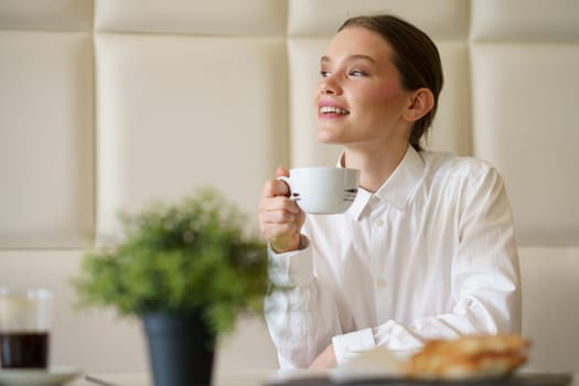 Happy businesswoman enjoying morning breakfast and coffee in a chic cafeteria