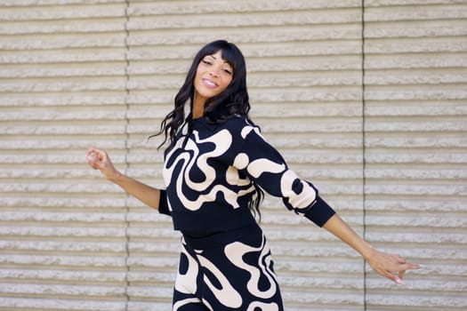 Passionate hispanic beauty dancer smiling at camera while performing in the city