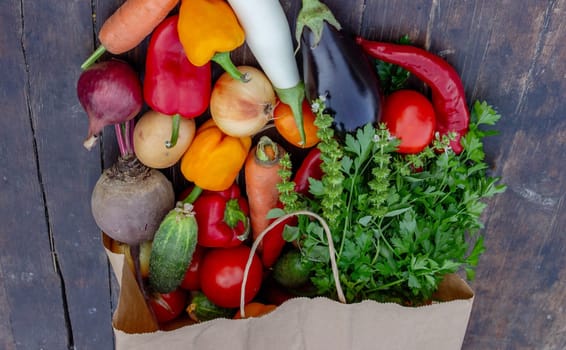 fresh vegetables on a wooden background in a paper bag. Selective focus.