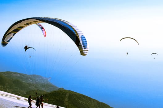 Paragliding from Babadag Mountain at Sunset overlooking Oludeniz near Fethiye in Turkey.