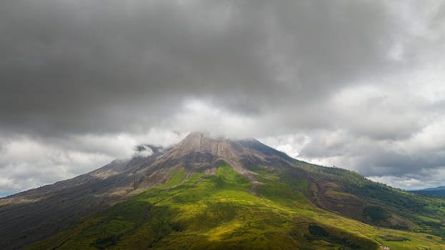 Aerial view of mount Sinabung active stratovolcano covered with clouds. Sumatra, Indonesia.