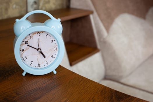 Alarm clock to notify bedtime is on shelf of home sofa in rest room, health benefits of sleep and right time to wake up