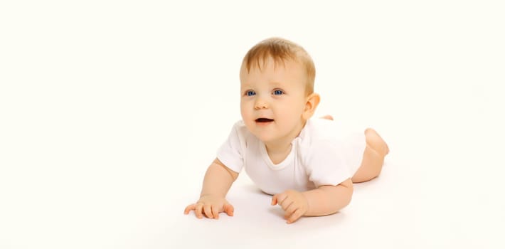 Portrait of happy cute baby crawling on the floor on white studio background