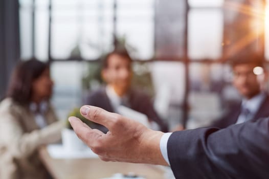 Hand of a businessman in a suit holding a pen