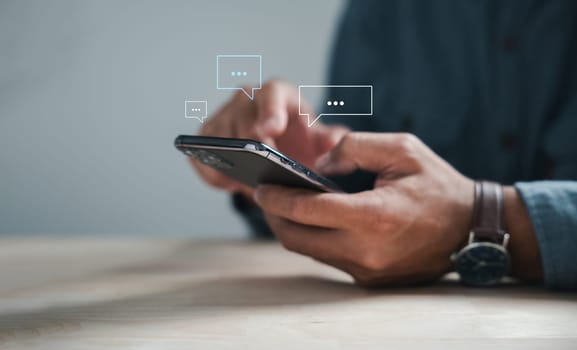 Modern connectivity man on phone types, discussing live chat and social network concepts. Home office with chat box icons portrays digital communication trends. Social media marketing technology