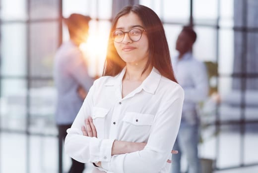 a girl stands in a modern office and looks at the camera