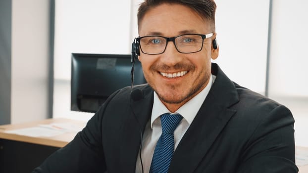 Business people wearing headset working in office to support remote customer or colleague. Call center, telemarketing, customer support agent provide service on telephone video conference call. Jivy