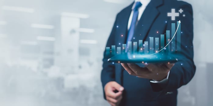 Businessman is holding a tablet to display a graph with percentage signs for the future growth plan of his organization. Finance, management, plan, management, strategy.