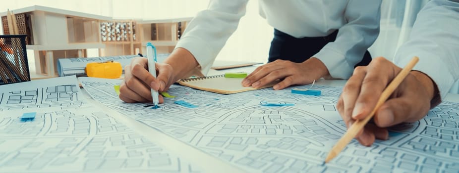 Worker, architect and engineer work on real estate construction project oratory planning with cartography and cadastral map of urban town area to guide to construction developer business plan of city