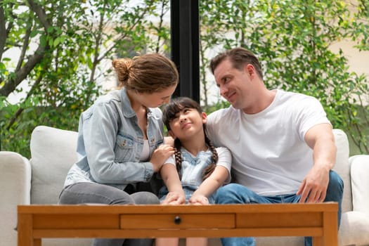 Parents comforting their daughter with loving hug, helping her feel secure and protected from fear, rest her head on shoulder. Happy family love and child care support concept. Synchronos