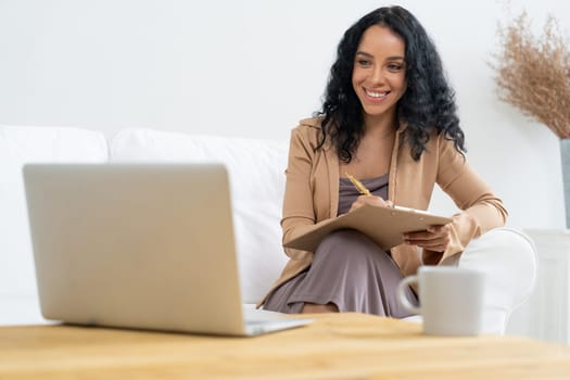 African-American woman using laptop computer for crucial work on internet. Secretary or online content writing working at home.