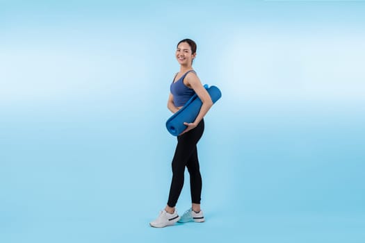 Young attractive asian woman portrait in sportswear with exercising mat. Healthy exercise and workout routine lifestyle concept. Studio shot isolated background. Vigorous