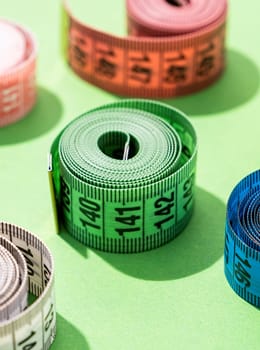 Dieting concept. colorful measuring tapes on bright green background, pattern