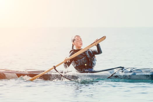 Happy smiling woman in kayak on ocean, paddling with wooden oar. Calm sea water and horizon in background