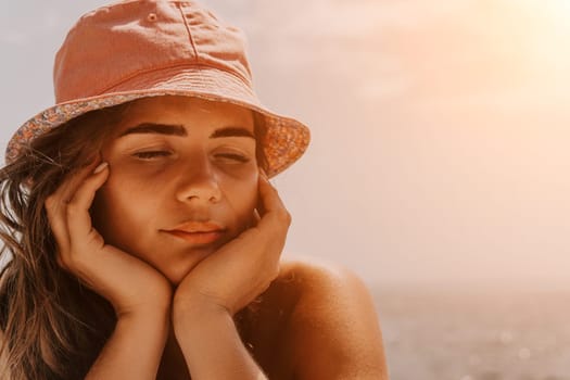 Happy smiling young woman sunbathing or tanning on a seaside beach during summer vacation. Slow motion of happy tourist in red swimsuit enjoying sun tan lying on beach chair lounge at luxury resort.