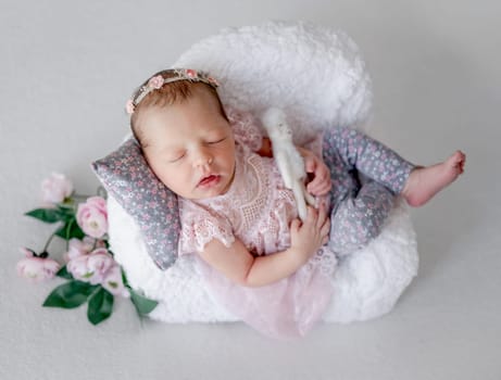 Baby Girl Sleeps On Tiny Chair In Newborn Studio Photo