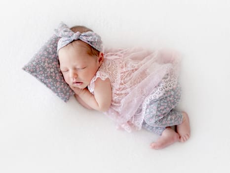 Baby Girl Sleeps On White Blanket In Studio Photo Of Newborn