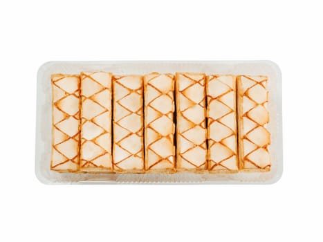 Italian crispy sweet bakery Sfogliatine glassate isolated on white background. Tasty cookies with apricot glaze puff pastries in container. Top view.