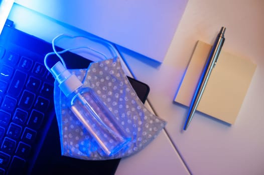 Sanitizer anti virus spray on the working table with laptop. Personal hygiene concept. Concept of quarantine for coronavirus and working from home.