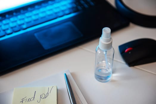 Concept of loss and searching job by reason of coronavirus covid-19. Sanitizer anti virus spray on the working table with laptop.