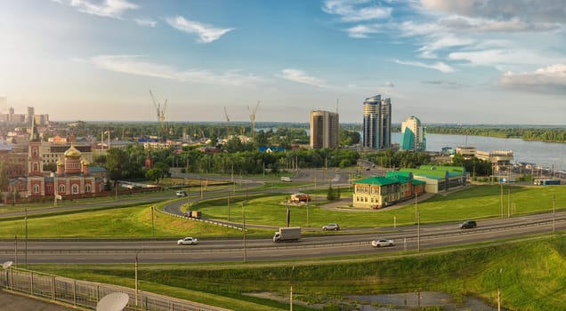 Panoramic picture of road and cars driving, summer sunny day in Barnaul, Siberia, Russia