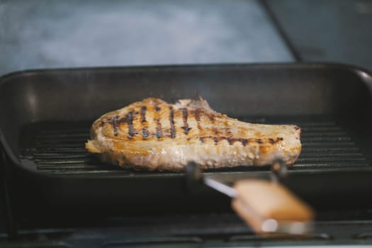 The meat on the grill cooked in restaurant close-up