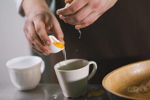 Cook separates the whites then yolks to the bowl close up