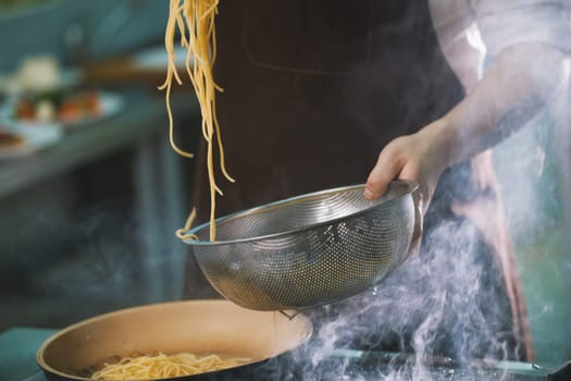 Process of cooking spaghetti in restaurant close-up