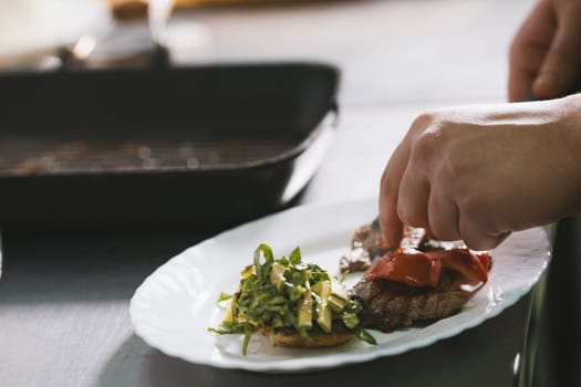 Chef serves steak on the plate in restaurant close-up