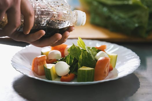 Chef serves salad on the plate in restaurant close-up