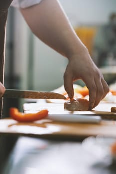chef cuts the meat in commercial kitchen close-up