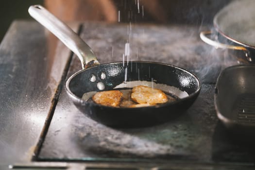The meat on the pan cooked in restaurant close-up