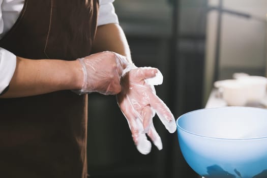 The chef wears gloves to mix the salad close up