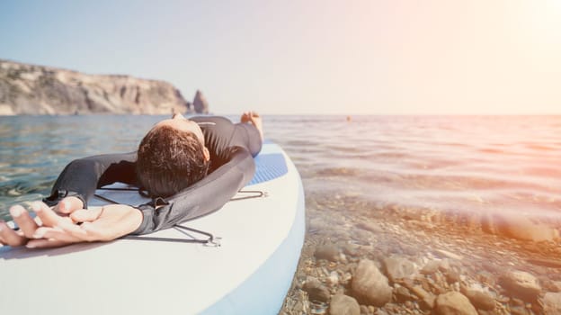 Woman sup yoga. Middle age sporty woman practising yoga pilates on paddle sup surfboard. Female stretching doing workout on sea water. Modern individual hipster outdoor summer sport activity