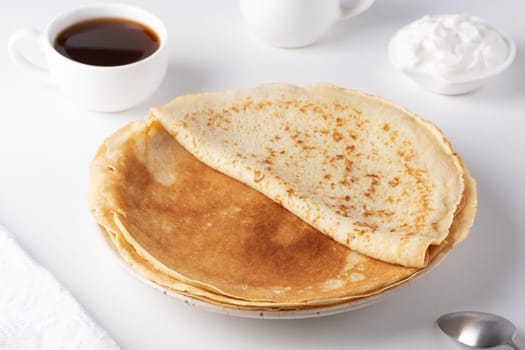 Stack of traditional russian pancakes blini on white background. Homemade russian thin pancakes blini. Russian food, russian kitchen.